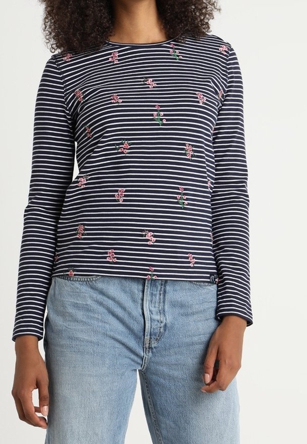 Marinblå och vit randig långärmad topp med små rosa blommiga broderidetaljer. Mjuk tyg, rund hals, något kortad design.