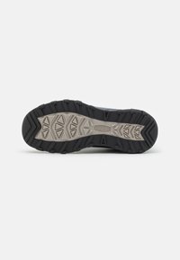 Schwarze Wanderschuhsohle mit strukturiertem Gummi-Oberfläche, ausgestattet mit einem geformten Zwischensohlen-Design und einem dreieckigen Profilmuster für besseren Halt.