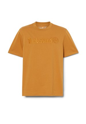 Short-sleeve mustard yellow T-shirt made of soft cotton. Features embossed "Timberland" text and logo on the front. Simple, classic design.