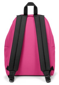 Mochila rosa con correas acolchadas negras, un asa superior y textura de tela suave. Sin marcas visibles ni detalles adicionales.