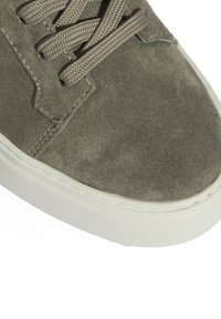 Graue Wildleder-Sneaker mit einer strukturierten Oberfläche, versehen mit gewebten Schnürsenkeln und einer weißen Gummisohle. Minimalistisches Design mit dezenten Nahtdetails.