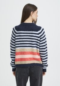 Pull rayé avec une palette de couleurs marine, bleu et rose. Il présente un col rond et un tricot texturé, avec une coupe décontractée.
