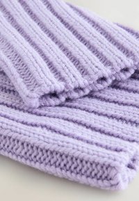 Lavendelfarbener Strickstoff mit ribbeliger Textur, der dickes, weiches Garn aufweist und abwechselnde erhabene Streifen für einen visuellen und taktilen Kontrast bietet.
