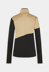 Långärmad topp med hög krage, färgblockdesign i beige och svart, med en slät yta och figursydd silhuett.