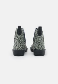 Botas de tobillo con patrón floral verde, suela de goma negra, paneles laterales elásticos y tiradores para una fácil puesta.