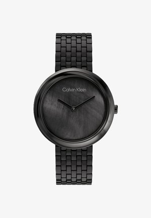 Černé kovové hodinky s kulatým ciferníkem, texturovaným černým podkladem, minimalistickými značkami a spojeným náramkem. Na hodinkách je logo Calvin Klein.