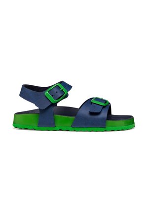 Sandalo blu navy con suola verde brillante e due fibbie verdi regolabili, una sulla cinghia alla caviglia e una sulla cinghia delle dita.