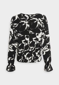 Blusa nera con un motivo floreale bianco, maniche lunghe con polsini arricciati e un fit rilassato con un piccolo dettaglio di piega sul retro.