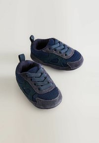 Ett par marinblå sneakers för småbarn med detaljer i mesh och mocka, elastiska snören och dragflikar på en ljus bakgrund.