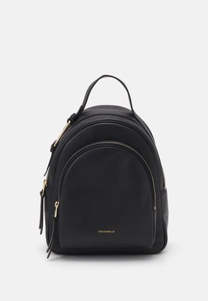 Black leather backpack with a rounded shape, two zippered compartments, and a top handle. Features gold hardware and textured surface.