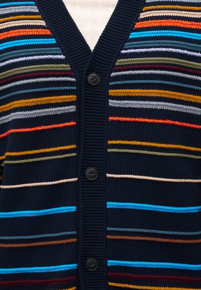 Καρντιγκάν σκούρου μπλε με πολύχρωμες οριζόντιες ρίγες και τρία μαύρα κουμπιά κατά μήκος ριμπ υφασμένης V-λαιμόκοψης.