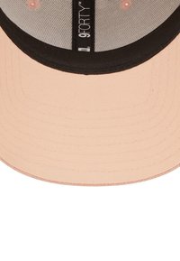 Baseballmütze mit einem Pfirsich-farbenen Außenmaterial und einem schwarzen Schirm, ausgestattet mit einem Mesh-Innenfutter und einem Schild mit der Aufschrift "9FORTY".
