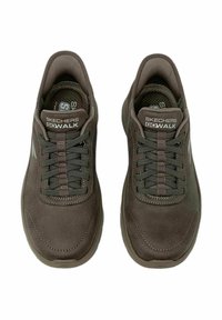 Zapatillas marrones Skechers Go Walk con una textura de ante suave, puntera redonda, suela plana de goma, diseño con cordones y logotipo en la lengüeta.