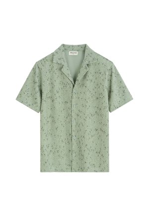 Chemise verte claire à manches courtes avec boutons, tissu texturé et petits motifs abstraits noirs, avec col et étiquette Frilivin à l’intérieur.