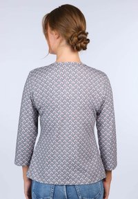 Langärmliges Oberteil mit Rundhalsausschnitt, aus gemustertem Stoff mit grauem Hintergrund und pastellfarbenen Blumenmotiven.