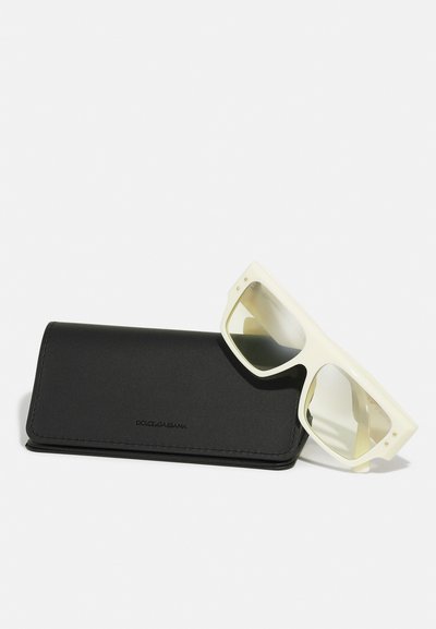 Ochelari de soare Dolce & Gabbana cu un cadru alb cremos și lentile cu gradient deschis, acompaniați de un etui elegant din piele neagră.