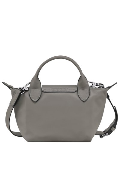 Kleine graue Lederhandtasche mit abgerundeten Obergriffen, abnehmbarem Schultergurt und geprägtem Logo auf der Vorderseite; glatte Textur, minimalistisches Design.