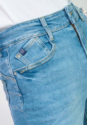 Lichtblauwe denim jeans met een slim fit, voorzien van een ritssluiting aan de voorkant, twee zijzakken en een klein merkembleem op de zak.