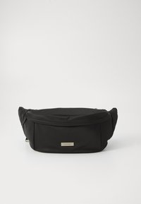 Zwarte nylon heuptas met een gladde textuur, gebogen vorm en een voorvak met rits. Beschikt over een gouden logo plaat.