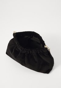 Saco em veludo preto, com um topo franzido, detalhes em metal dourado, textura suave e um interior espaçoso.
