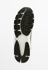 Semelle de chaussure de sport grise avec caoutchouc noir texturé pour l'adhérence, avec une semelle intermédiaire blanche et un détail de marque. Taille 42 indiquée.