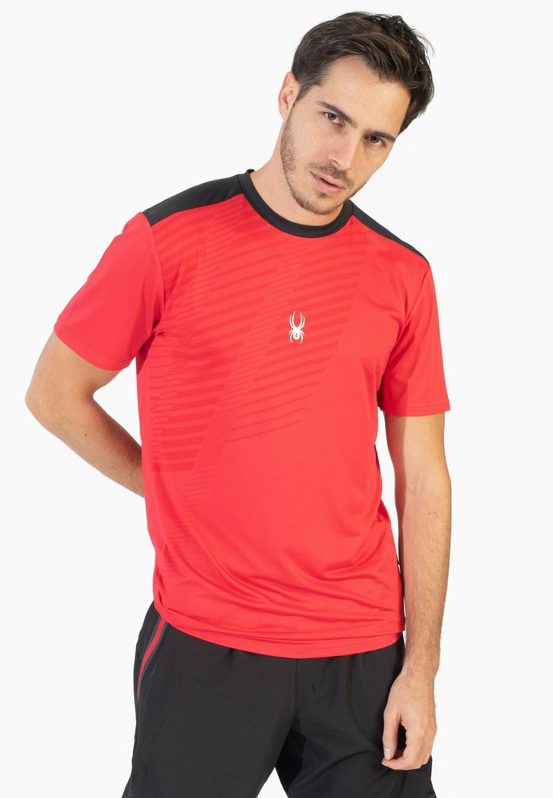 Camiseta deportiva roja con cuello negro, que presenta un patrón diagonal texturizado y un pequeño logotipo blanco en el pecho. Manga corta.
