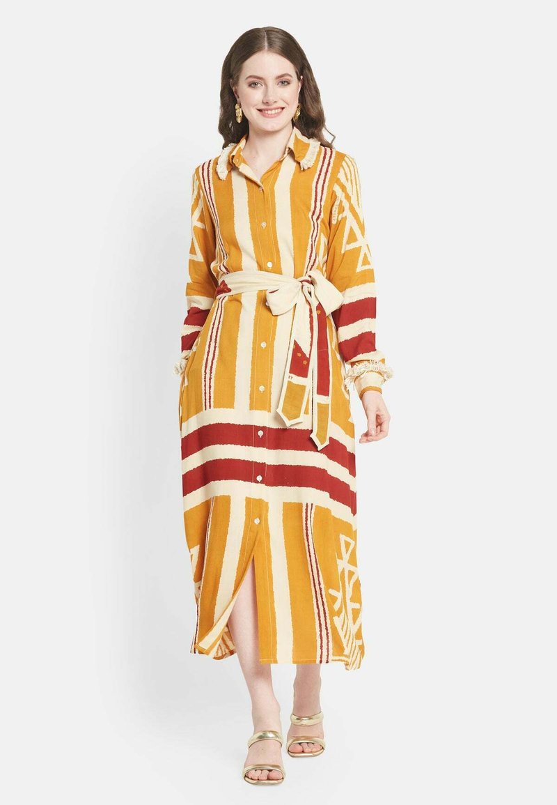 Lungo abito a camicia con una base gialla e righe rosse e crema, vita con cintura e polsini arricciati. Tessuto in cotone morbido.