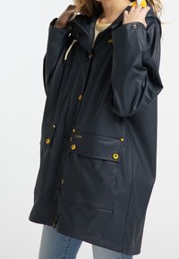 Impermeabile blu navy con cappuccio, dotato di bottoni a pressione dorati, due tasche anteriori e decorazioni con cordino per una vestibilità regolabile.