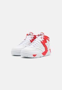 White basketball sneakers with red accents, featuring a high-top design, mesh panels, padded collar, and rubber sole. Logo on tongue.