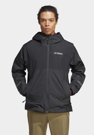 Giacca nera resistente agli agenti atmosferici con cappuccio, zip frontale e logo Terrex. Presenta una texture liscia e polsini elastici. Design leggero.