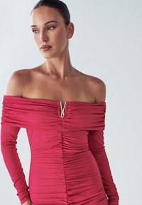 Šaty s odhalenými ramenami a dlhými rukávmi v textúrovanom tmavoružovom odtieni s riasením na prednej strane a ozdobným zipsom pri výstrihu.