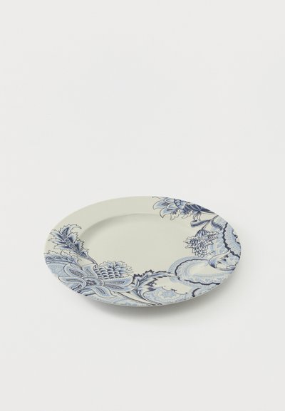 Assiette ronde en céramique blanche avec des motifs floraux bleus complexes et des motifs cachemire le long du bord sur un fond blanc.