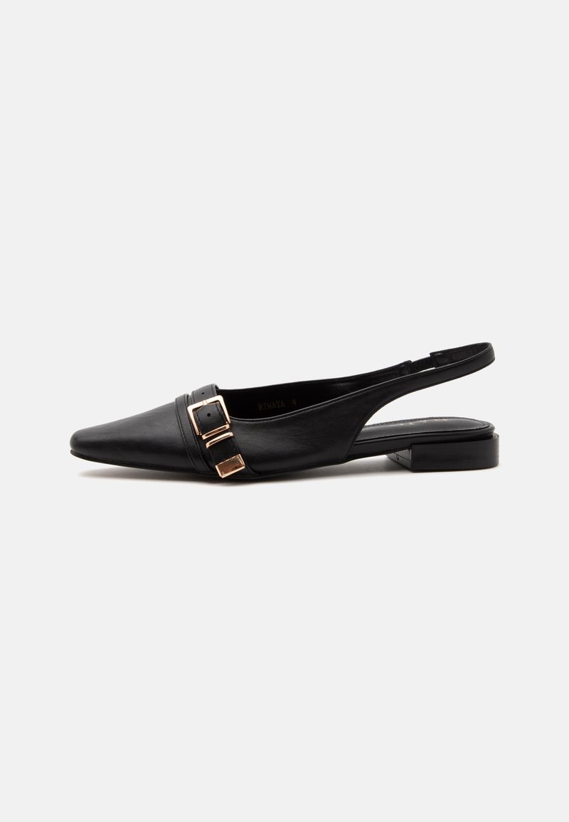 Chaussure plate slingback en cuir noir avec bout pointu et détail de boucle dorée sur le côté, présentée sur un fond blanc uni.