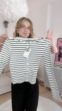 White long-sleeve shirt with black horizontal stripes, featuring a round neckline and button-down front, made of a soft, lightweight material.