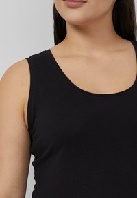 Schwarzes ärmelloses Tanktop mit rundem Ausschnitt, aus weichem, elastischem Stoff. Verfügt über eine glatte Textur und ein tailliertes Design.