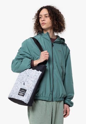 Chaqueta ligera verde con capucha. Bolsa de mano gris con detalles negros y un patrón gráfico de íconos y texto.