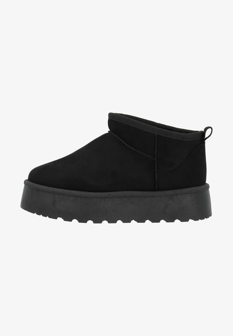 Bottine noire à la cheville avec semelle épaisse, design slip-on, matière supérieure douce et languette à l’arrière, vue de côté.