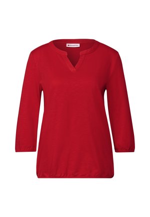 Rotes Oberteil mit V-Ausschnitt und drei Viertelärmeln. Weicher Stoff mit glatter Textur und ohne sichtbare Muster oder Akzente. Lockere Passform.