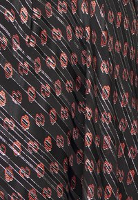 Czarna tkanina z powtarzającym się czerwonym i białym wzorem, zawierająca stylizowane motywy oraz cienkie ukośne linie, gładka tekstura.