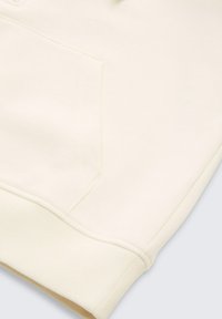 Crème kleurig sweatshirt met een zachte textuur, voorzien van een voorzak en geribbelde boorden voor een comfortabele pasvorm. Eenvoudig ontwerp, zonder patronen of accenten.