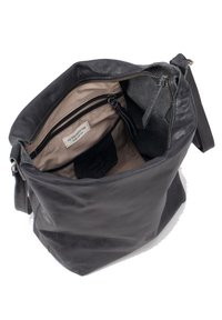 Borsa a spalla in pelle nera con texture morbida, chiusura zip e numerose tasche interne. Foderata con un tessuto leggero e dotata di una piccola etichetta.
