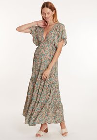Floral maxi-jurk met een diepe V-hals, korte fluttermouwen en een geraffineerde taille. Heeft een kleurrijk patroon met roze en groene tinten.