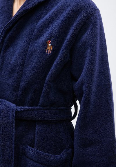 Μπλε ναυτικό μπουρνούζι από πετσέτα με ζώνη, με μικρό κεντημένο λογότυπο παίκτη πόλο πάνω σε άλογο στο στήθος.