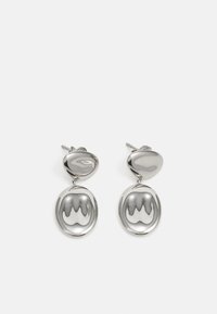 Brincos em prata com um topo arredondado e polido, e um pendente circular e refletivo com um padrão ondulado.