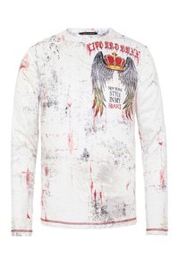 Langärmliges weißes Shirt mit einem angespannten Muster in rot und schwarz, Flügel- und Kronengrafik sowie dem Text "New York Style in My Heart".