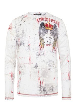 Langärmliges weißes Shirt mit einem angespannten Muster in rot und schwarz, Flügel- und Kronengrafik sowie dem Text "New York Style in My Heart".