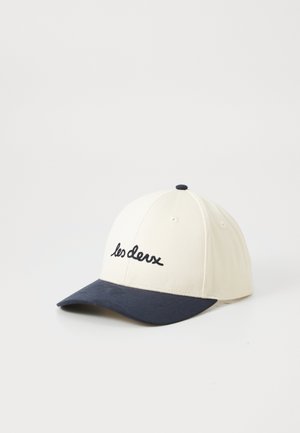 Hvid og marineblå baseballkasket med "les deux" broderet i sort skrift på frontpanelet, placeret på en ensfarvet hvid baggrund.