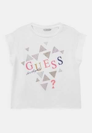 Hvid t-shirt med korte ærmer med farverig "GUESS Los Angeles" tekst og spredte metalliske trekantmønstre foran.