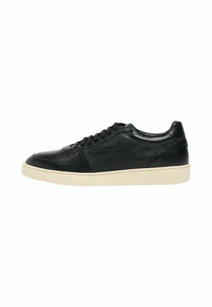 Basket basse en cuir noir avec lacets noirs et semelle en caoutchouc blanche, vue de profil extérieur sur fond blanc.
