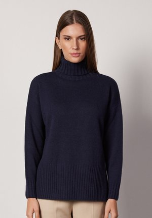 Granatowy sweter z golfem wykonany z miękkiej dzianiny, z prążkowanymi mankietami i dołem dla dodatkowej tekstury. Luźny krój z komfortowym dekoltem.